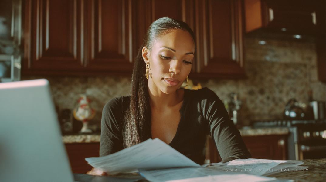 Person at desk reviewing Weatherization Assistance Programs and utility rebate forms for energy-saving upgrades
